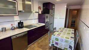 A compact kitchen with a dishwasher, microwave, and refrigerator. There is a dining table with a patterned tablecloth. - Centrally located apartment in Sarria (Sarria)