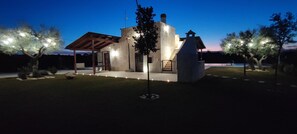 A modern house with a stone facade, a wooden pergola, and a well-lit entrance. - Gorgeous Countryside Villa with Infinity Pool (Castellana Grotte)