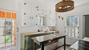 A modern kitchen with white cabinets, a wooden countertop, and a large window. - NEW LISTING!! Charming home in STOWE VILLAGE steps to Trails, Dining & Adventure (Stowe)
