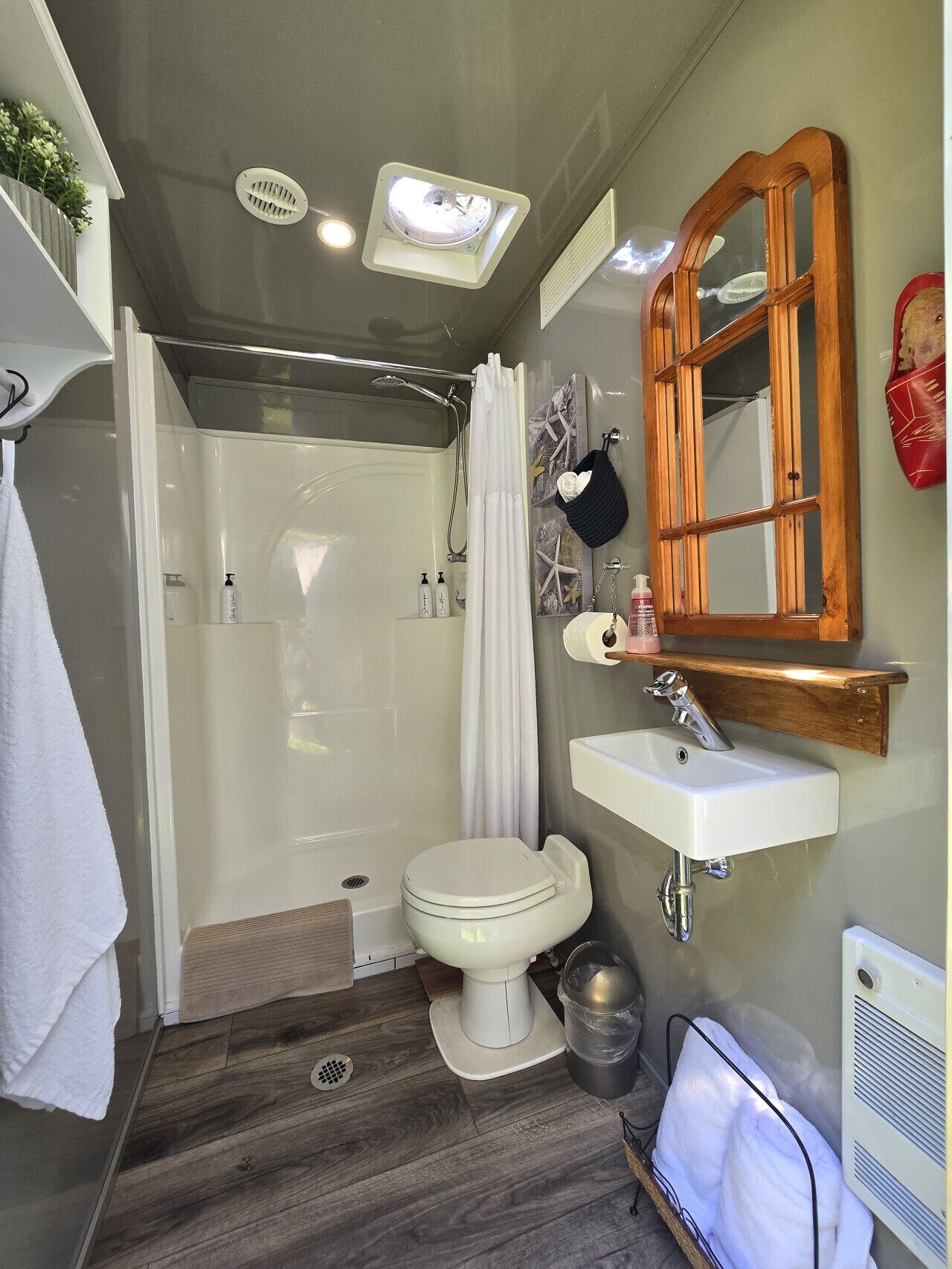 Une petite salle de bain comprenant une douche, des toilettes et un lavabo.