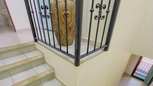 A staircase with a handrail and a decorative wall piece. - Jade A13 - Tropical Two-Story Retreat with Pool Views (City Playas del Coco)