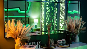 Un comptoir d’accueil agrémenté d’un miroir, de plantes décoratives et d’un espace dédié au café.