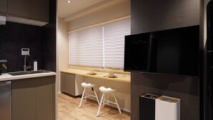 A modern kitchen with a built-in oven, a sink, and two bar stools.