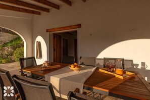 Enjoy a romantic meal for two in this charming outdoor dining area, complete with a beautifully set table and a refreshing centerpiece.