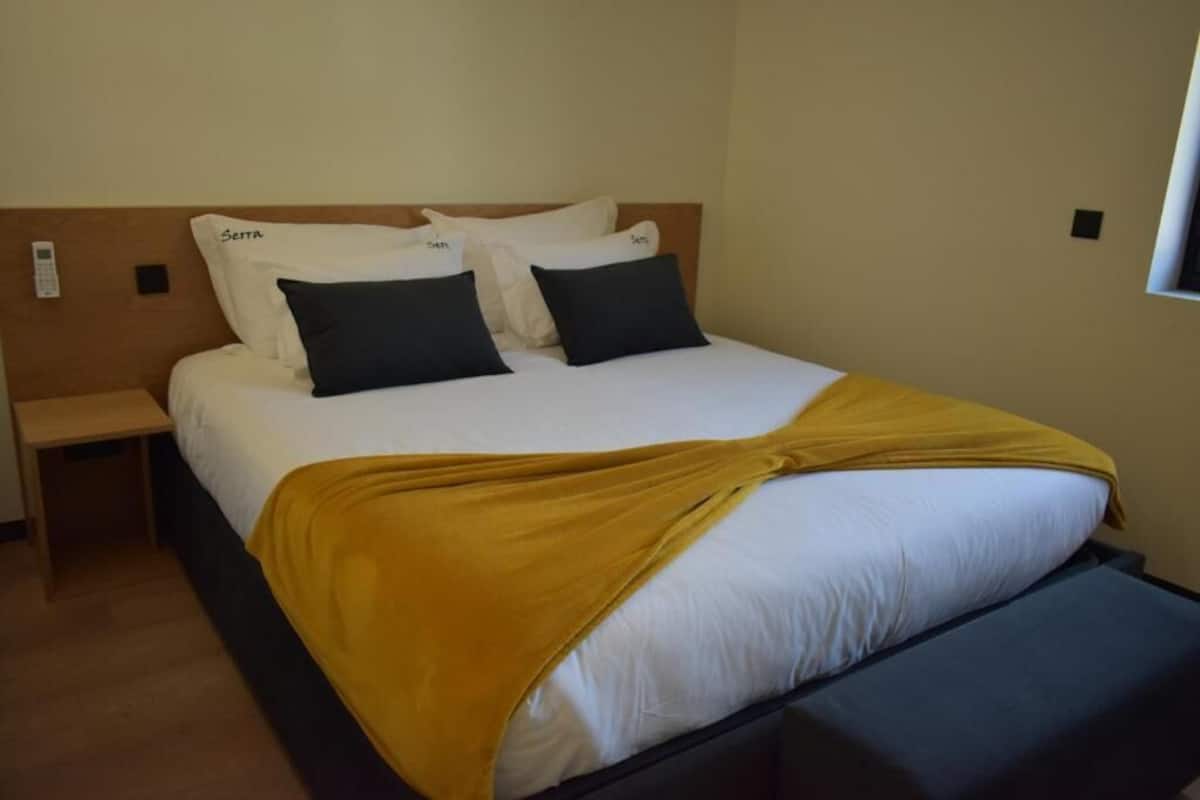 Ein Hotelzimmer mit einem Bett, einem Nachttisch und einem Fenster.