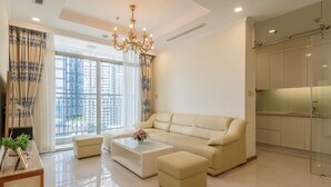 A modern living room with a beige sofa, a coffee table, and a chandelier.
