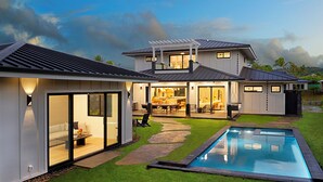 A modern house with a swimming pool, large glass doors, and a patio area. - Modern Kauaʻi Luxury Home With Ohana, Pool, and Spa in Kukuiʻula (Koloa)