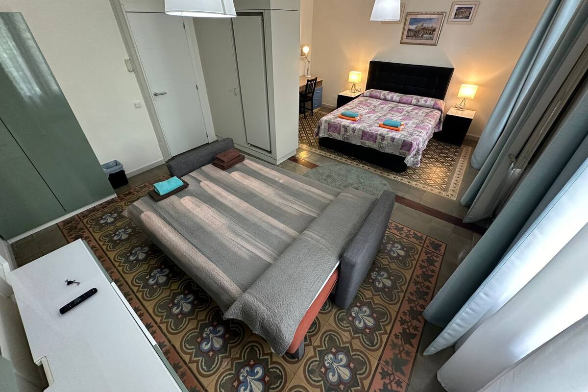 A hotel room with a bed, a desk, a wardrobe, and a bathroom.