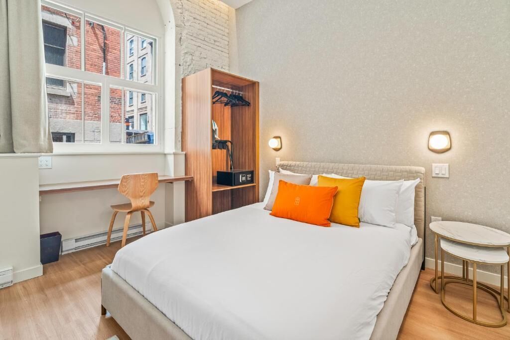 Un dormitorio con una cama, un armario de madera, un escritorio y una silla.