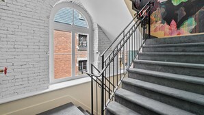 A staircase with a metal railing leading to a landing. - Arcadia Hotel Boutique (Montréal)