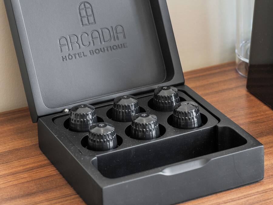 Una caja negra con el texto "ARCADIA HOTEL BOUTIQUE" y cuatro perillas en la tapa.