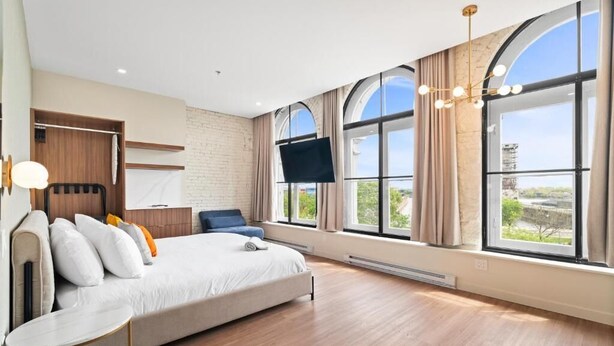 A modern bedroom with a large bed, a desk, and a TV. - Arcadia Hotel Boutique (Montréal)