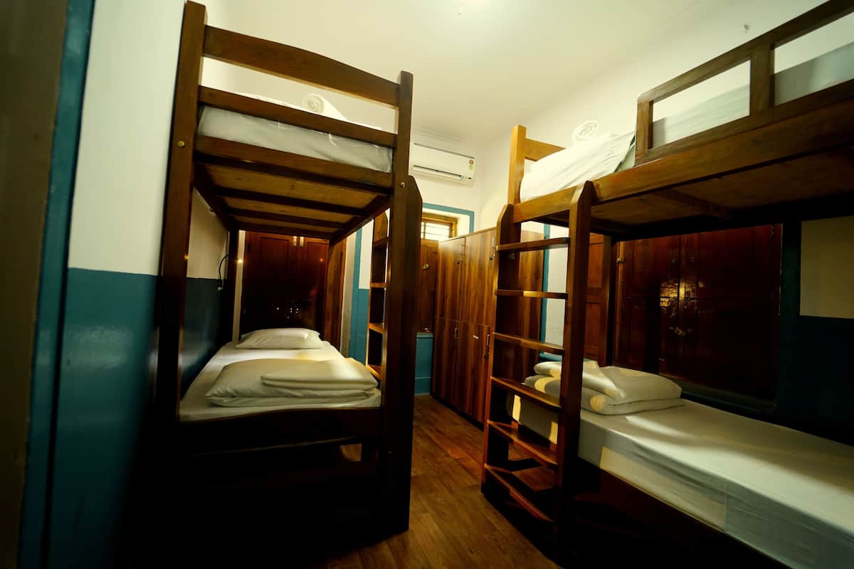 Une chambre avec des lits superposés, des meubles en bois et une fenêtre.