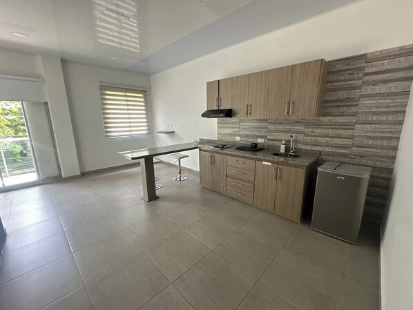 A modern kitchen with a large island, built-in cabinets, and a refrigerator. - 97 loft (Cali)
