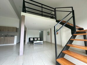 Un interior moderno con una escalera, una zona de cocina y un área de estar.