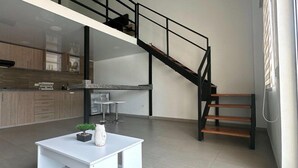 Un appartement moderne doté d’une cuisine, d’un coin repas et d’un escalier.