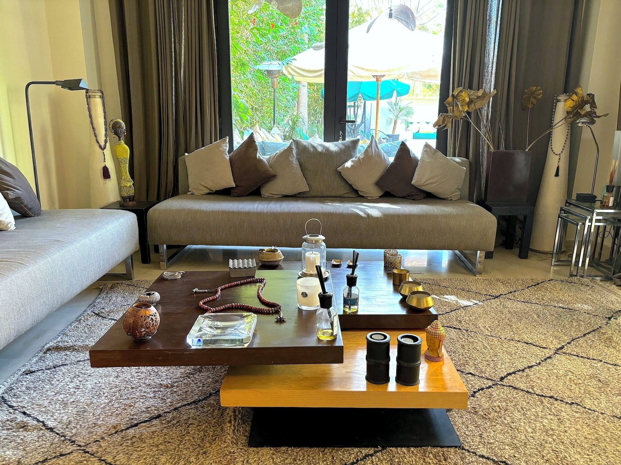 Uma sala de estar moderna com um sofá, uma mesa de centro e vista para um jardim exterior.