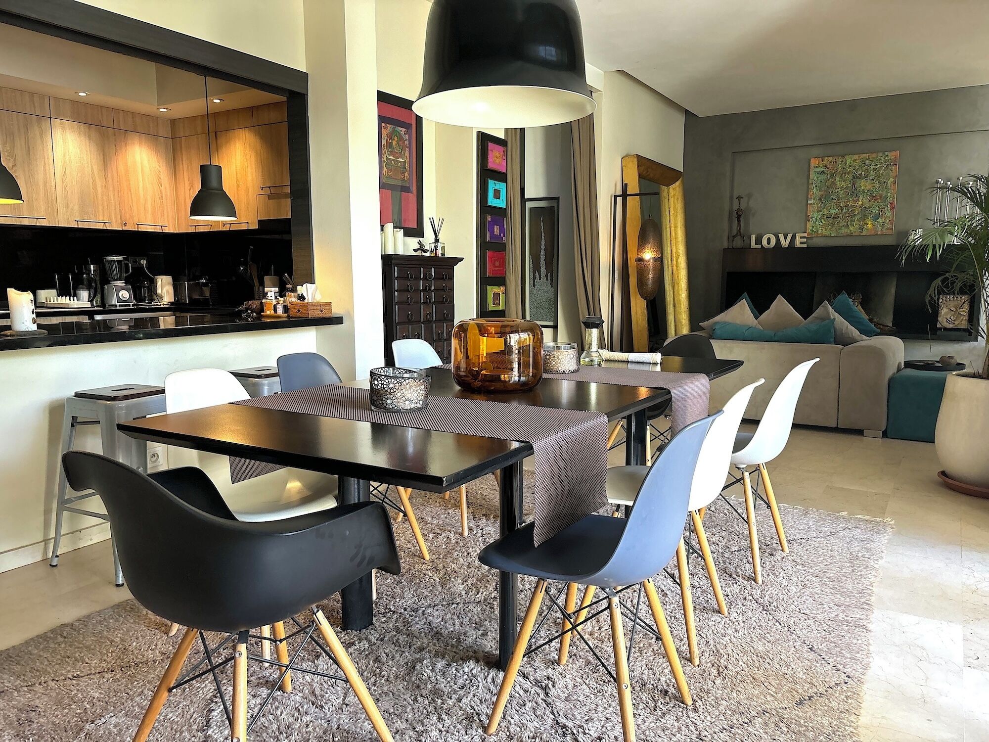 Una sala de estar moderna con comedor, que incluye un sofá, sillones, una mesa de centro y una chimenea.