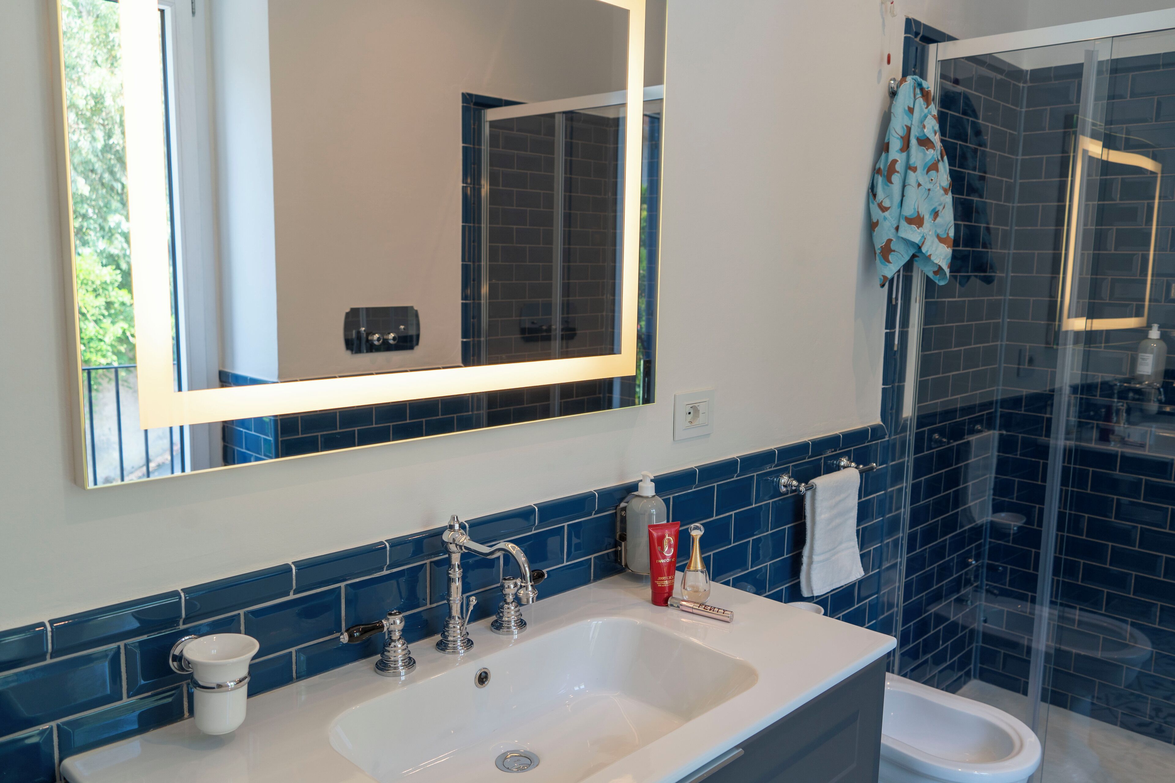A bathroom with a white sink, a mirror, and a glass shower enclosure.