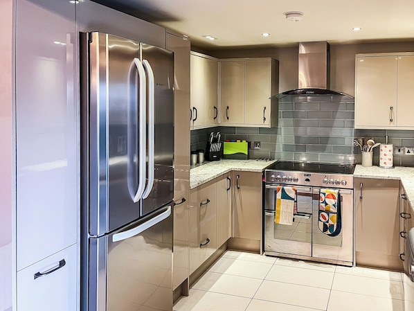 Una cocina moderna con electrodomésticos de acero inoxidable, estufa a gas y horno empotrado.