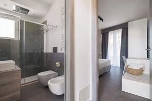 Une salle de bain moderne avec une douche à parois de verre, des toilettes et un bidet.