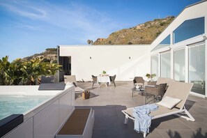 Une terrasse sur le toit avec une piscine, des chaises longues et un espace repas.