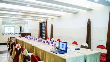 A conference room with a long table, chairs, laptops, and water bottles.