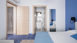 Una habitación de hotel moderna con cama, baño y vestidor.