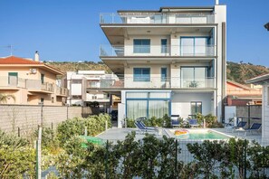 A modern multi-story building with a swimming pool, balconies, and a view of the surrounding area. - Terraces d'Orlando (Capo d'Orlando)