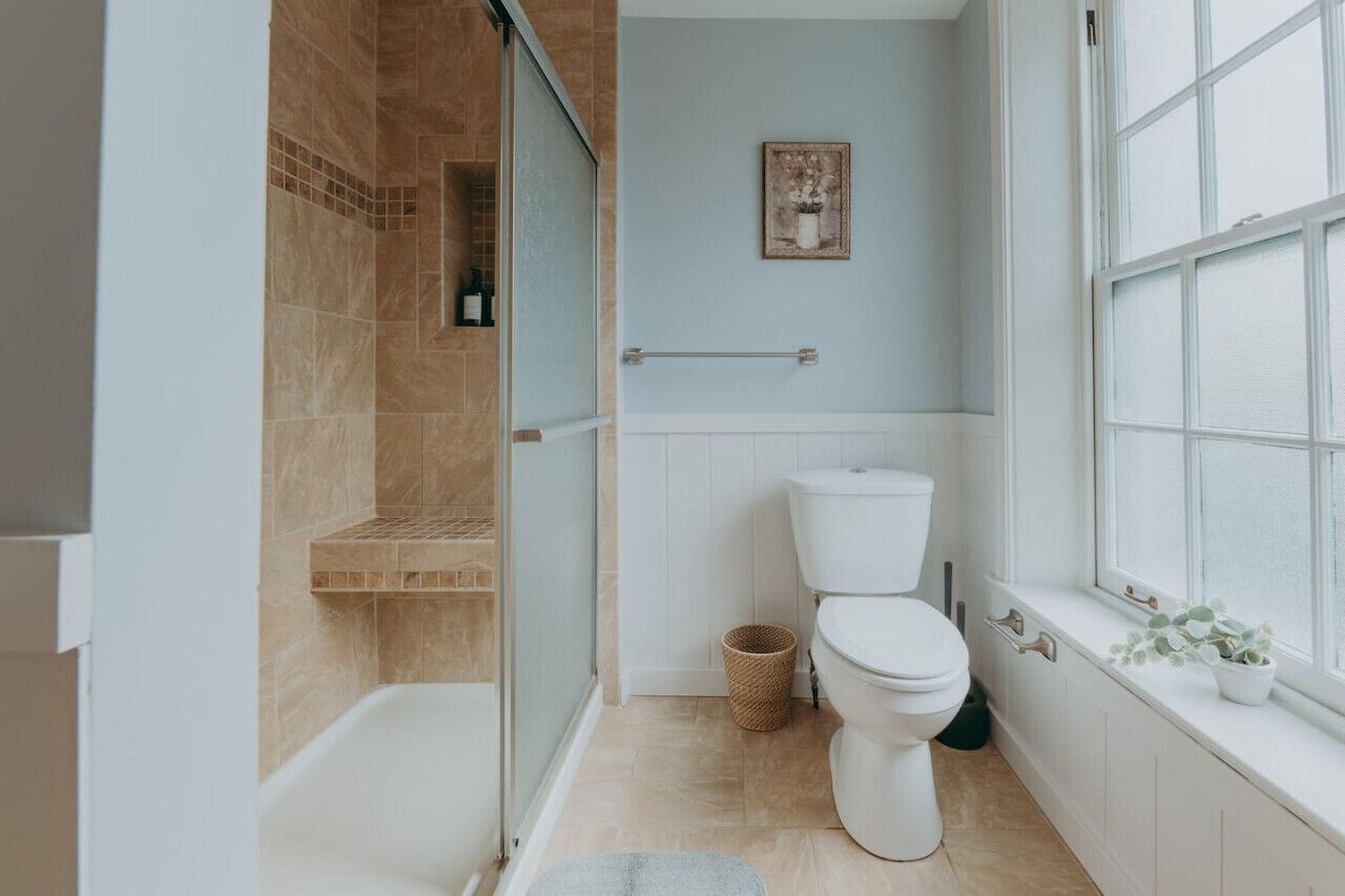 Une salle de bain moderne avec une douche, des toilettes et une fenêtre.