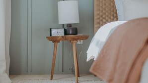 A bedroom with a bed, a bedside table with a lamp, and a wall clock. - The Maisonette on Duke | King Bed, Chic, Downtown Lancaster (Lancaster)