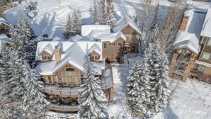 A large, multi-story lodge with a snow-covered roof and surrounding trees. - Hot Tub + Close to Skiing – Lariat Ridge Lodge (Steamboat Springs)