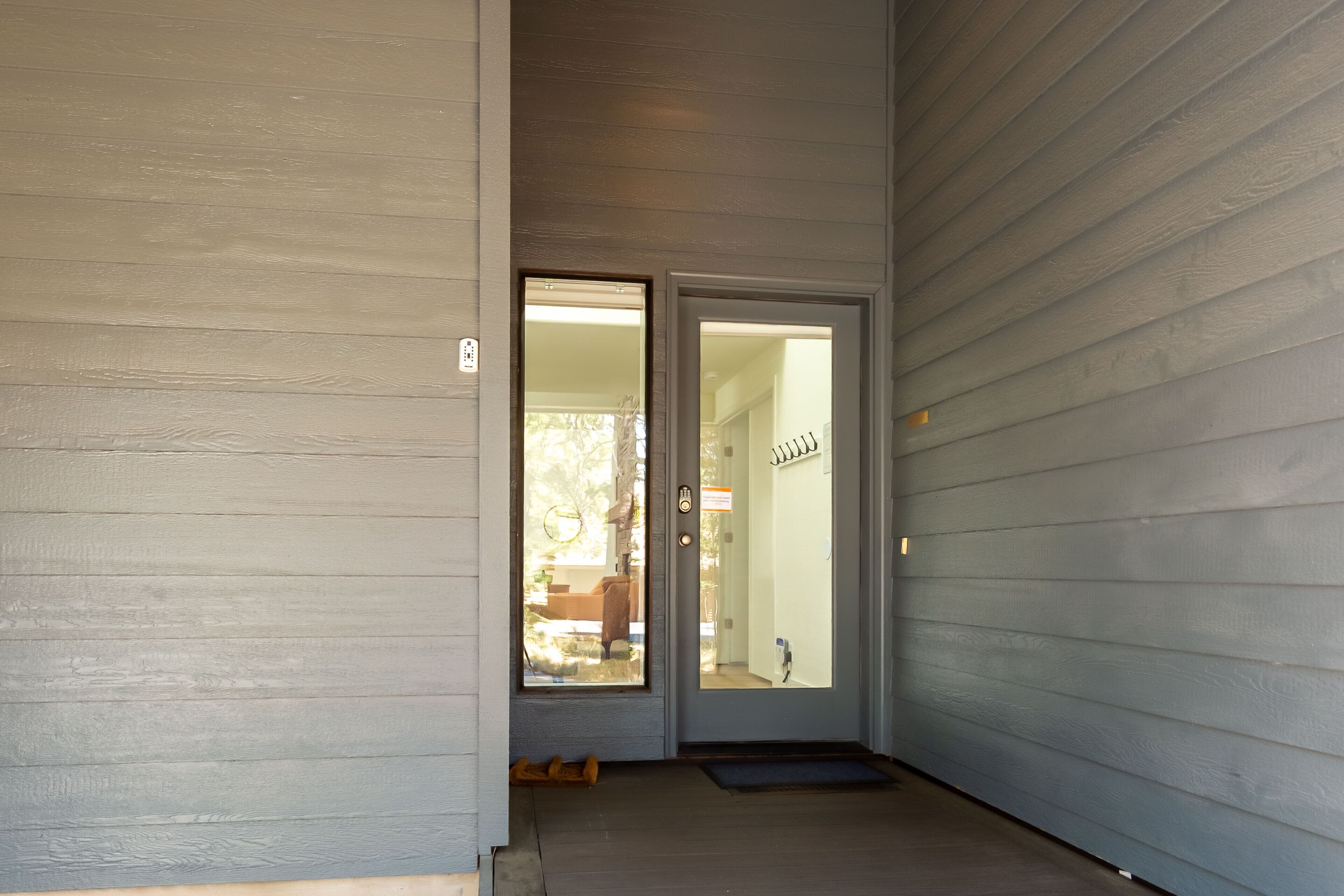 A front door with a glass panel, a doormat, and a small step leading to the entrance.