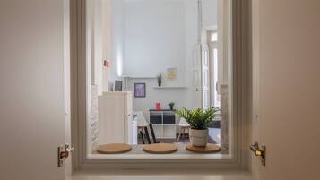 A modern interior with a dining area, a refrigerator, and a potted plant.