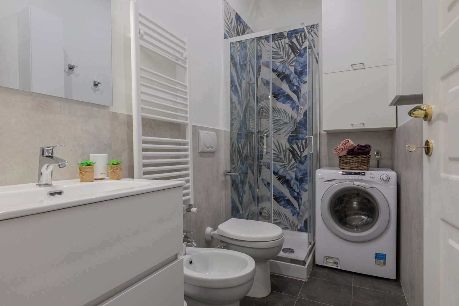 A compact bathroom with a toilet, bidet, and washing machine.