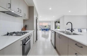 Enjoy cooking in this well-equipped kitchen with a central island, gas stove, and sink.