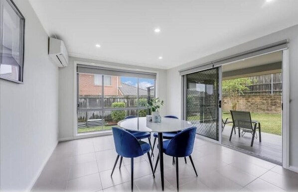 Enjoy a meal at the round table with four chairs in this stylish room, offering a view of the outdoors.