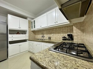 Een koelkast met diepvriezer, een oven, een kookplaat, een vaatwasser