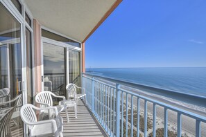 A balcony with white plastic chairs and a view of the ocean. - Roxanne Towers 1201-Oceanfront 2BR/2BA-Pool (Myrtle Beach)