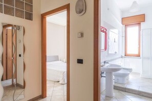 Une chambre d’hôtel avec un lit, une salle de bain comprenant un lavabo et des toilettes, et une vue sur l’extérieur.