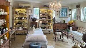 Une pièce confortable avec un lit, une armoire en bois contenant divers objets, une bibliothèque et un lustre.