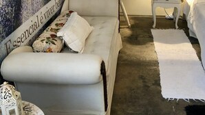 Une chambre à coucher comprenant un lit, un canapé, une table de chevet et un mur orné de tableaux encadrés et d’une décoration murale.