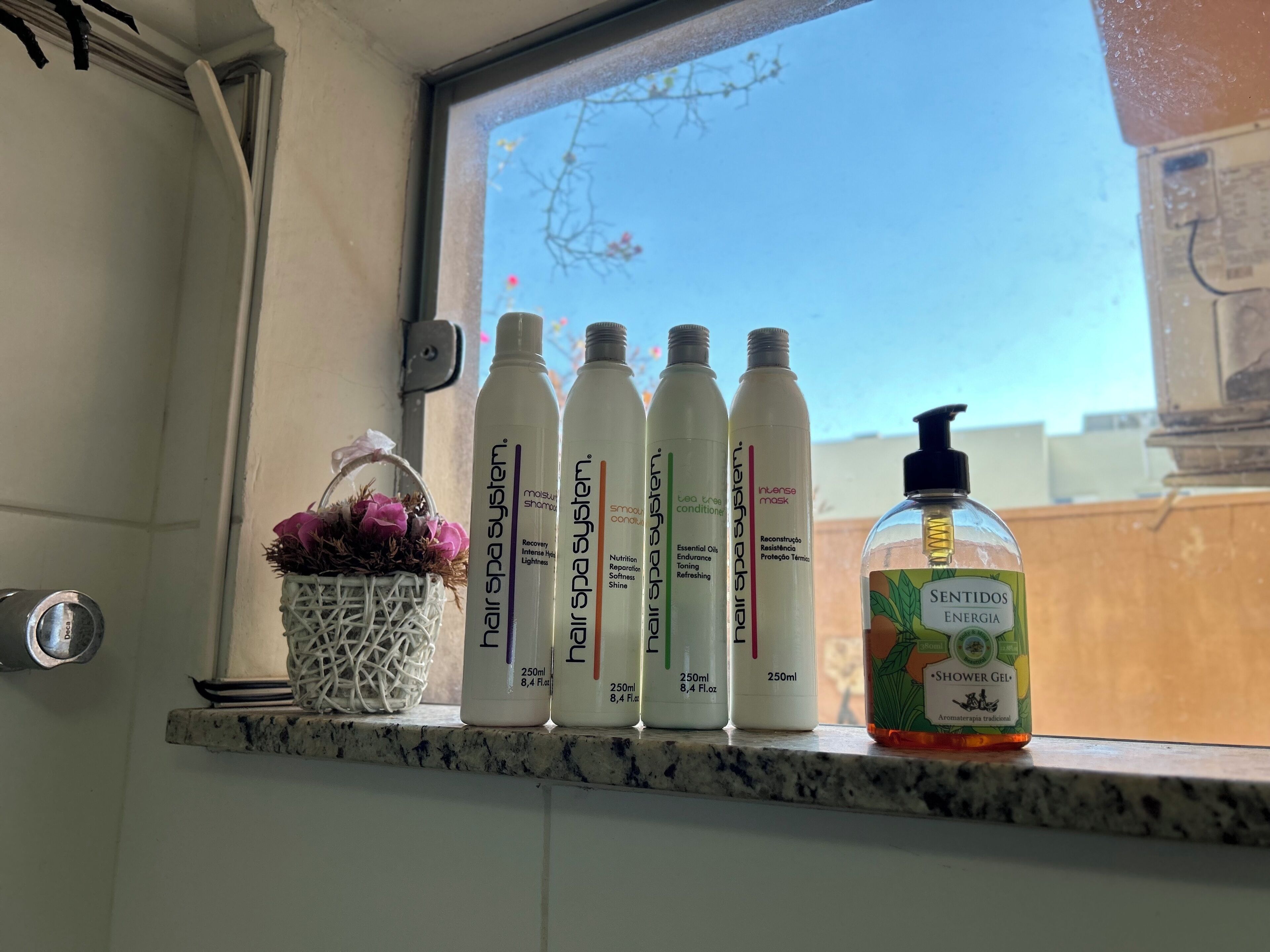 Een badkamerplank met diverse spa-producten en een fles traditionele aromatherapie gel.