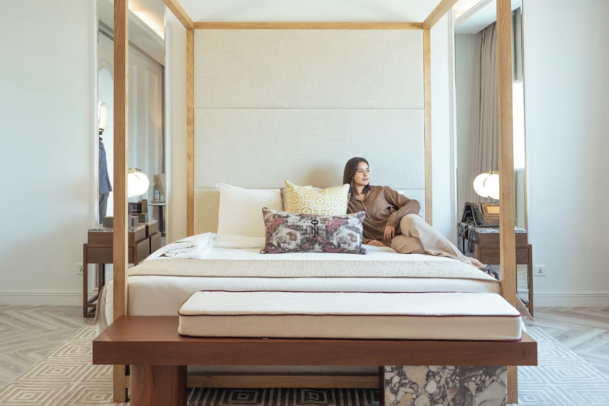 Een bed met baldakijn, met houten frame, matras en kussen.