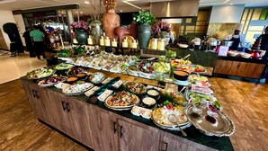 Un buffet proposant divers plats et boissons, un buffet en bois et un vase décoratif.