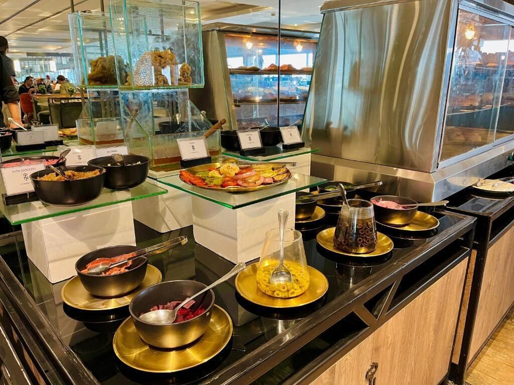 A buffet with various food items displayed in bowls and containers.