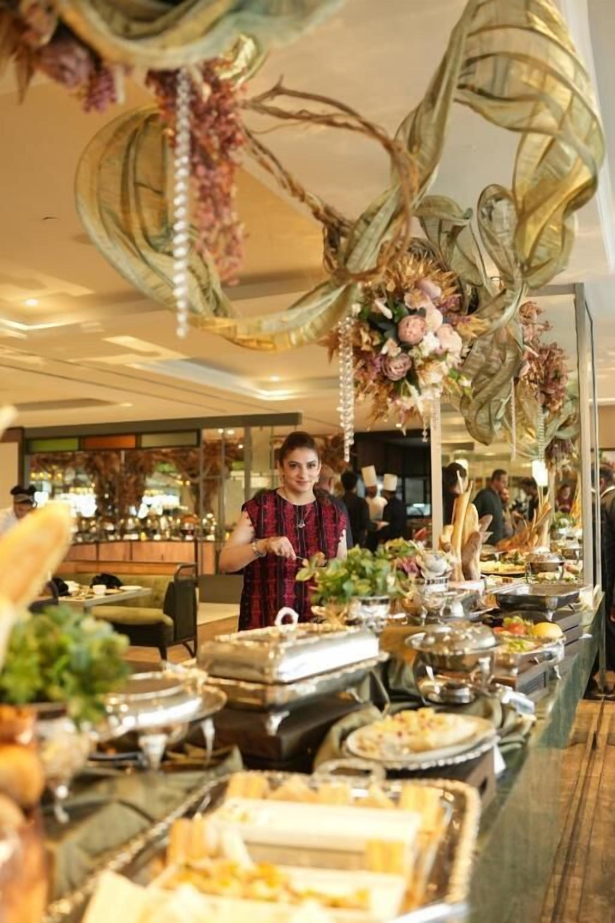 A buffet setup with various food items and a decorative hanging arrangement.
