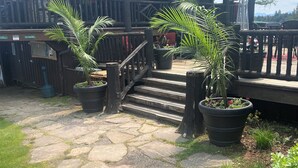 Una terraza de madera que conduce a un edificio con un cartel que dice 'The Boot House'.