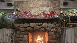 Una sala de estar acogedora con chimenea de piedra, un sofá de cuero y una mesa de centro de madera.