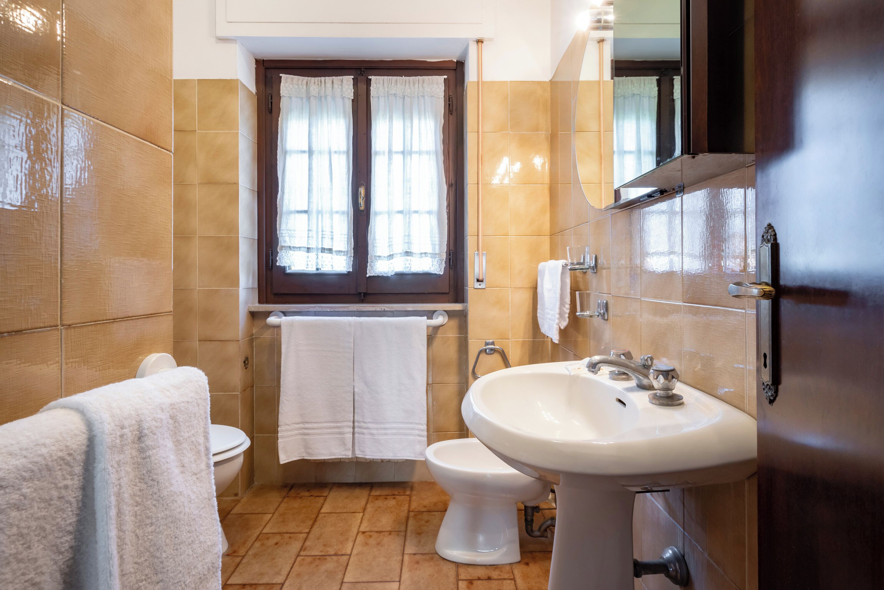 Une salle de bain équipée de toilettes, d’un bidet et d’un lavabo.